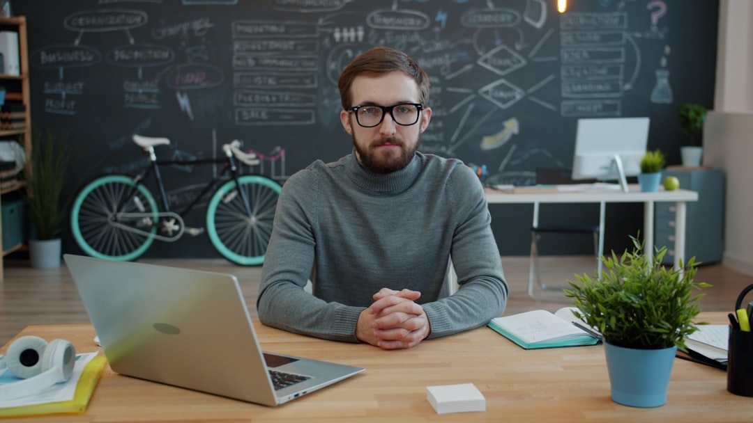 Equipe pequena de negócios colaborando em torno de notebook em escritório moderno
