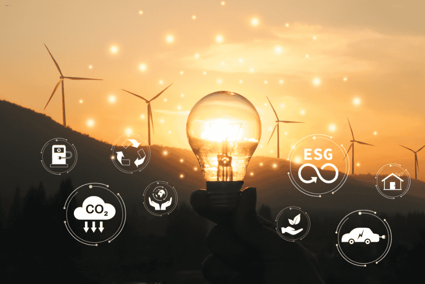 Lâmpada com ícones ESG e turbinas ao fundo ao pôr do sol