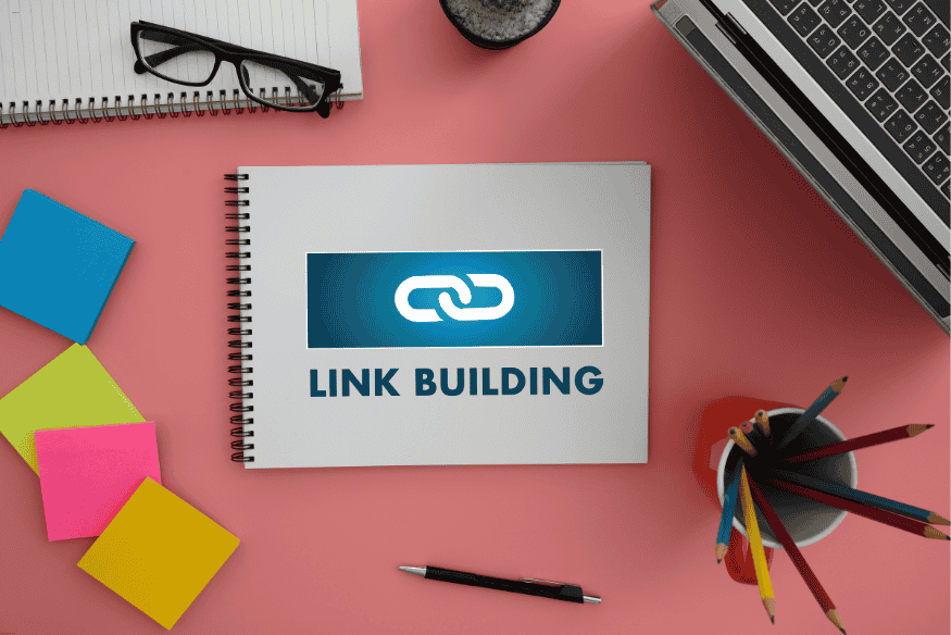 Caderno com a inscrição 'Link Building' sobre mesa de trabalho, ilustrando planejamento de SEO