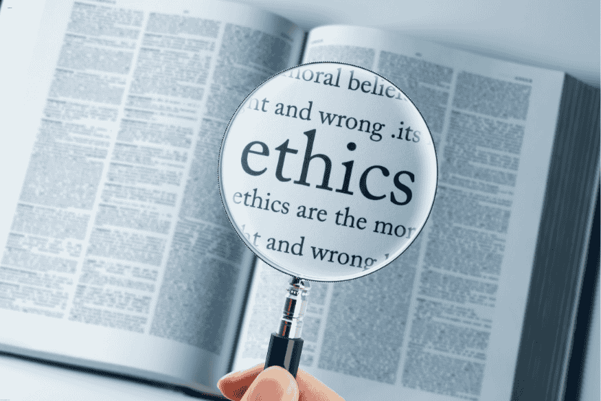 Lupa focando a palavra “ethics” em uma página de dicionário aberta, simbolizando a importância de diretrizes morais para IA.