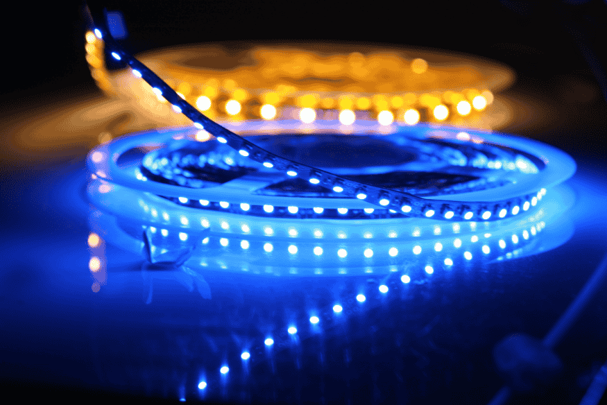 Fitas de LED azul e amarela acesas sobre superfície reflexiva