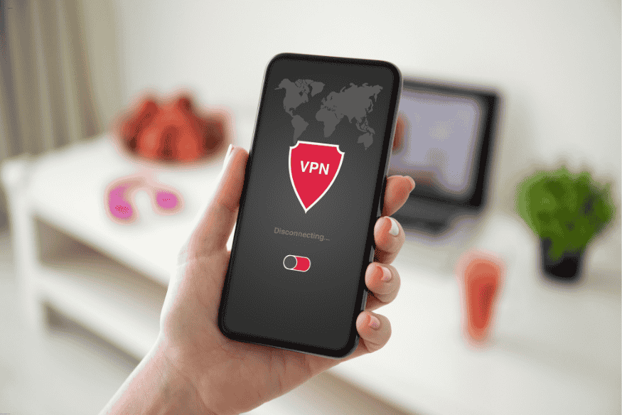 Mão segurando smartphone com aplicativo de VPN sendo desconectado recentemente