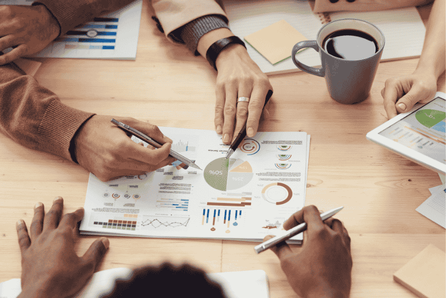 Equipe analisando gráficos de marketing com foco em dados de conversão e comportamento do consumidor.
