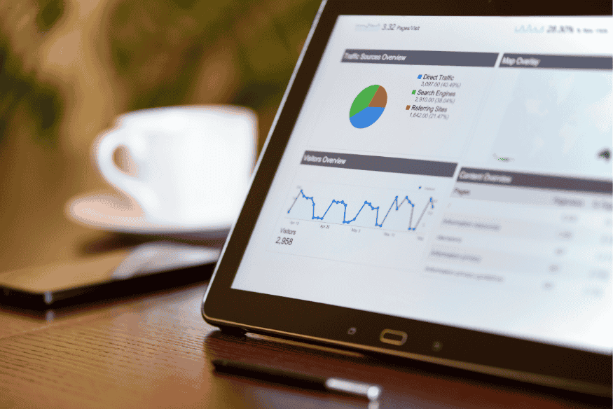 Tablet exibindo painel com gráficos de tráfego, fontes de visitantes e comportamento de usuários.