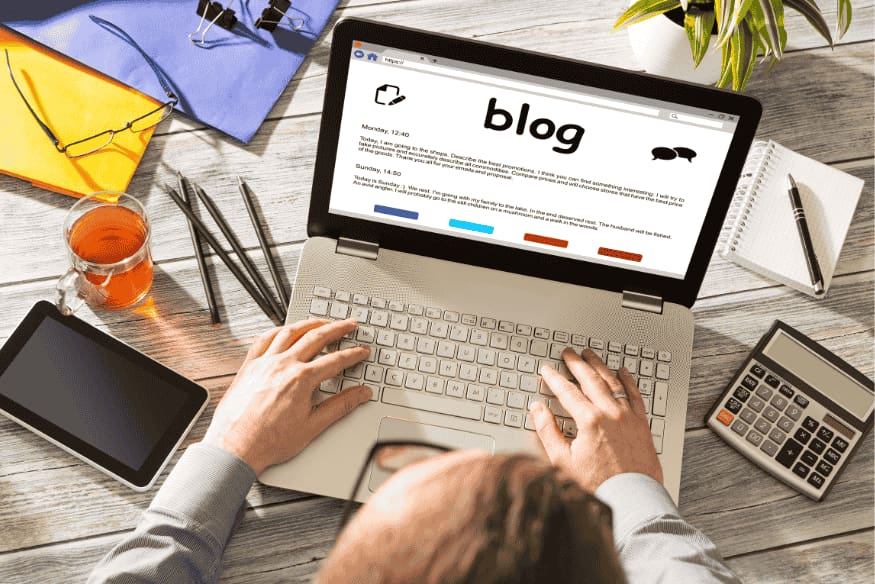 Homem digitando em notebook com blog aberto