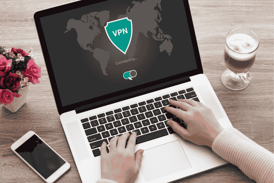 Pessoa usando notebook com VPN conectando para navegação segura em 2025