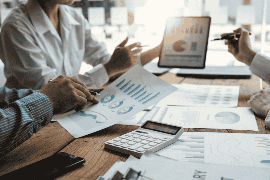 Equipe de marketing analisando gráficos e dados em reunião estratégica.