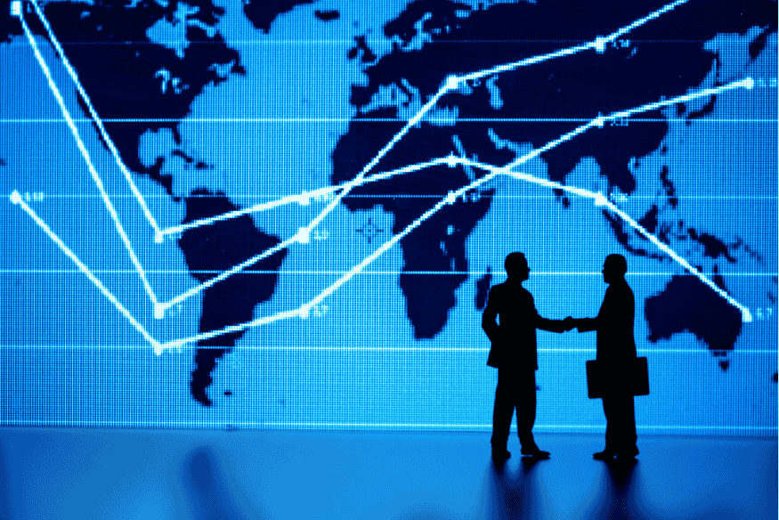 Dois executivos se cumprimentando diante de mapa mundial com dados interligados