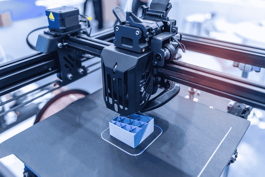 Impressora 3D industrial fabricando componente técnico com estrutura interna reforçada.