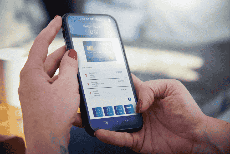 Mulher usando app bancário com saldo e transações exibidas na tela do celular.