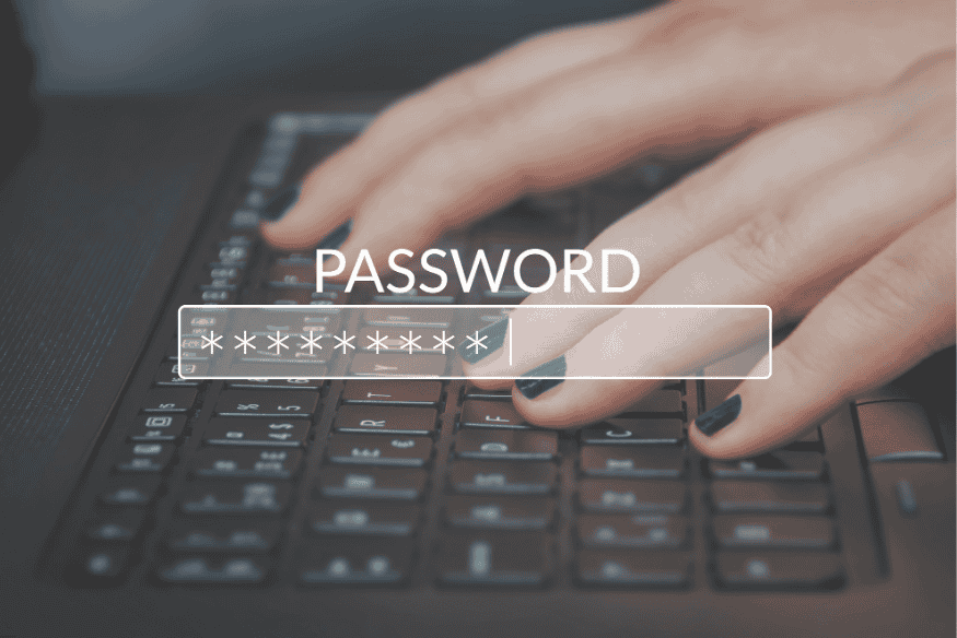 Pessoa digitando senha em teclado com campo de senha oculto na tela.