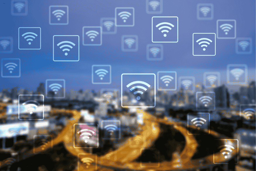 Ícones de Wi-Fi espalhados sobre cidade à noite, simbolizando múltiplas redes sem fio em ambientes urbanos.