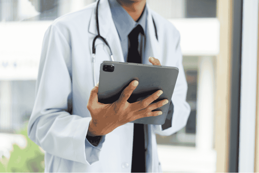 Médico segurando tablet com prontuário digital apoiado por IA para tomada de decisão no diagnóstico.
