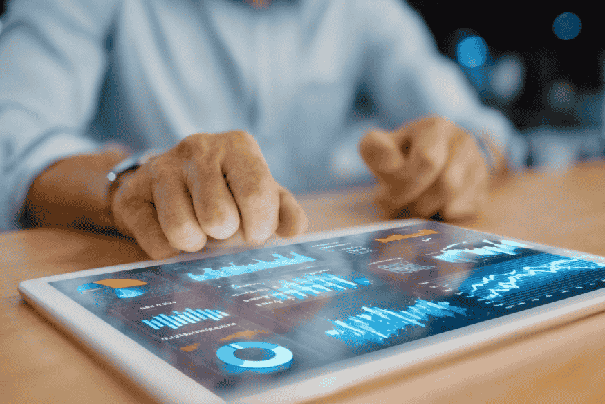 Gestor analisando dashboards em um tablet com gráficos de desempenho gerados por modelos de IA explicável
